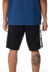 Bermuda deportiva negra de tela satinada con laterales con botones a presión y franja blanca en contraste. Logo Vernal bordado en blanco. Inspirada en la estética de los joggings adidas vintage.