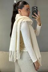 Bufanda de tejido de punto en color beige melange, con diseño rectangular y terminaciones con flecos en los extremos.