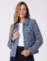 Chaqueta de tweed azul con cuello a la base, abertura central y bolsillos delanteros. Presenta detalles de denim en los bolsillos y puños, con botones perlados. Terminación desflecada y forro interno.