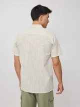 Camisa de manga corta con diseño a rayas verticales finas, cuello clásico y cierre frontal con botones.
