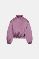 Chaqueta acolchada de cuello subido con cierre frontal de cremallera, manga larga con hombros marcados y puños elásticos. Presenta un diseño con bajo elástico y acabado satinado.