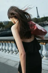 Vestido corto negro con cuello halter ajustable mediante lazada, cintura elástica y falda con drapeado lateral.