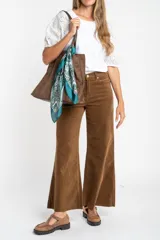 Pantalón de pana color marrón, de corte wide leg y tiro medio, con ruedo deshilachado.