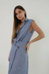 Top de lino mezcla con poliéster, color celeste melange, de corte chaleco con cuello camisero, sin mangas y abotonado al frente con botones de pasta efecto nácar. Cuenta con pretina lisa en la delantera, elástico ancho en la espalda, canesú con pliegues y charreteras en los hombros.
