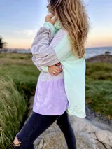 Polerón de corte holgado con mangas largas abullonadas, confeccionado en terciopelo negro con detalles en beige y blanco.