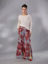 Pantalón de cintura alta y piernas amplias en lino mezcla, con estampado vegetal en tonos bordó, gris y blanco, y tajos asimétricos en las piernas. Cuenta con cierre invisible lateral y bolsillos.