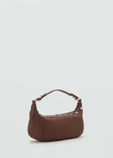 Bolso de hombro pequeño en color marrón, con diseño de media luna, asa corta y detalle de tachuelas metálicas decorativas a lo largo de la base. Cuenta con cierre de cremallera superior.