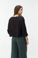 Blusa verde militar de manga larga con volados en el escote en V y lazos para atar al frente.