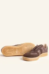 Zapatilla urbana de cuero vacuno y gamuza en color suela, con cordones al tono y suela de caucho. Diseño clásico con paneles combinados.