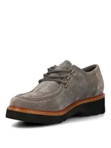Zapatos de gamuza color gris de la marca Hush Puppies, modelo Renovo. Presentan diseño robusto con cordones gruesos, ojales metálicos, suela gruesa track y costuras pespunteadas en el borde.