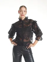 Blusa de tul bordado color negro, con cuello alto, cierre frontal con botones y mangas tres cuartos con terminación amplia.