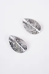 Par de caravanas de diseño ovalado con superficie texturizada y acabado metálico brillante.