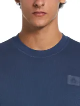 Buzo azul marino de escote redondo y manga larga de Original Penguin, confeccionado en tejido de algodón con textura de toalla de bucles. Presenta un calce slim fit, dobladillo recto y un pequeño parche con logo bordado en el pecho.