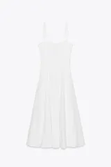 Vestido midi blanco de popelín con escote corazón y volantes en el borde superior. Presenta tirantes finos ajustables con lazos y falda acampanada.