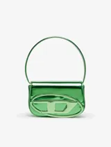 Bolso de hombro compacto con solapa, confeccionado en cuero con acabado espejado brillante color verde metálico. Presenta un asa corta para llevar al hombro y una placa ovalada con el logo 'D' de Diesel en relieve en la parte frontal.