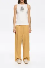 Pantalón mostaza de corte amplio y tiro alto, con cintura elástica.