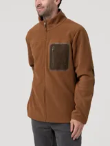 Polar de hombre color marrón (chestnut) con cierre frontal completo y cuello alto. Presenta un bolsillo superior en el pecho con cierre y ribete en color verde oliva.