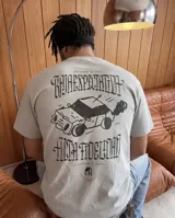 Remera de corte regular color gris, con estampa gráfica en la espalda que incluye un auto y la leyenda 'Baja expectativa, alta fidelidad'.