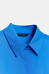 Camisa roja de cuello solapa, con mangas cortas abullonadas tipo globo y cierre frontal con botones ocultos.