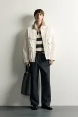 Parka relaxed fit de algodón color crudo, con cuello solapa marrón en contraste, múltiples bolsillos plastrón con solapa en el delantero y cierre frontal con cremallera y botones a presión.