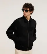 Campera masculina de estilo casual con cuello inglés, cierre frontal por cremallera, bolsillos laterales y ajuste elástico en el bajo. Presenta detalles de recortes en la parte superior delantera.