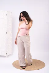 Pantalón de pierna ancha y tiro alto, color beige, con textura sutil y cintura elástica.