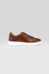 Championes de cuero color marrón con suela blanca y cordones al tono.