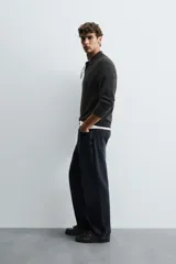 Polo de punto de corte regular fit, confeccionado en una mezcla de lana y cashmere. Presenta cuello solapa con cierre frontal de dos botones, manga larga y terminaciones en rib.