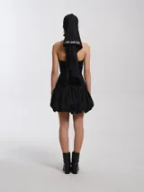 Top negro de lycra con escote halter, silueta entallada al cuerpo con ballenas, forrado con tejido tipo remería y espalda semi descubierta con cierres a la vista.