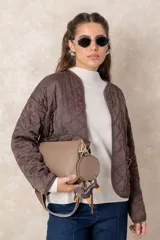 Campera corta de diseño capitoneado con patrón de rombos, color negro. Presenta cuello redondo, cierre frontal abierto, mangas largas y dos bolsillos delanteros con detalle de broche.