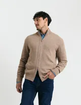 Cardigan de punto gris con cuello alto, cierre frontal de metal con doble cursor y bolsillos laterales. Presenta puños y cuello en tejido canalé.