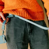 Llavero celeste con cinta de tela y gancho metálico.