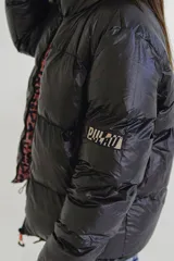 Campera puffer reversible de corte holgado, con cuello alto y cierre frontal. Un lado es de color azul vibrante con detalles en verde lima en el cierre y el interior, y el otro lado es de color negro.