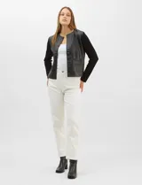 Chaqueta Sioni con frente de cuero sintético y mangas y espalda de tejido de punto. Presenta cuello a la base, cierre frontal con botones a presión y bolsillos delanteros.