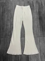 Pantalón acampanado de punto, color crudo, con cintura elástica y cordón ajustable.