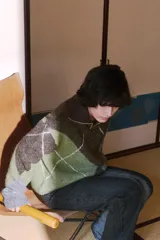 Jersey de cuello pico y manga larga, con estampado de rombos en tonos marrón, verde y gris, y acabados en rib.