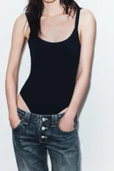 Body de cuello cuadrado con tirantes finos, confeccionado en tejido elástico con cierre inferior mediante botones a presión.