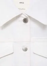 Chaqueta crop de denim blanco, confeccionada en algodón con un toque de elastano. Presenta cuello de solapa, cierre frontal con botones metálicos, bolsillos de parche con solapa en el pecho y manga larga con puños abotonados.