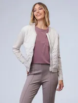 Campera bomber color beige, marca Elie Tahari. El frente es capitoneado con diseño de rombos, la espalda y las mangas son tejidas.