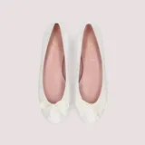 Bailarinas de charol blanco con lazo ajustable en la puntera, suela de goma antideslizante, plantilla de piel con memory foam y forro de tela.