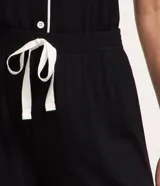 Pijama americano corto marca Lov de color negro, confeccionado en viscolycra. Incluye una blusa de manga corta con cuello, cierre delantero de botones y detalles de vivo contrastante, y un short con cintura elástica y vivo a juego en el ruedo.