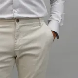 Pantalón de gabardina color azul marino, de corte ajustado y tiro medio, con cierre y botón frontal.