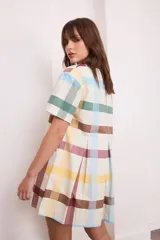 Vestido corto de algodón color negro, con mangas cortas, cuello redondo y diseño con tablas frontales y traseras que le otorgan una caída holgada.