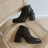 Botas cortas de cuero negro con textura símil serpiente, plataforma y taco ancho cuadrado.