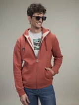 Buzo tipo hoodie con cierre frontal completo, capucha con cordones ajustables y bolsillos laterales. Confeccionado en tejido de algodón con textura jaspeada.