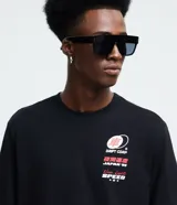 Remera negra de corte comfort y manga corta, con cuello redondo y estampado de estilo urbano con un auto rojo y un dragón en la espalda.