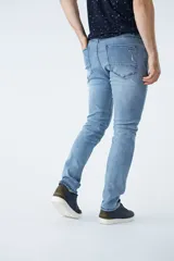 Pantalón de jean corte regular, color azul oscuro, con diseño de cinco bolsillos, pasacintos y detalles de roturas localizadas en la parte frontal.