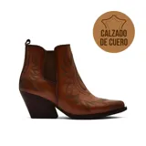 Bota texana de cuero color marrón con costuras decorativas bordadas en el empeine y los laterales. Presenta un diseño de caña baja con elástico lateral y taco cuadrado de madera.