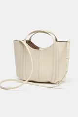 Bolso de mano tipo mini city, color borgoña, con pespuntes en contraste. Presenta asa de mano y asa bandolera extraíble. Incluye una bolsa interior extraíble con cierre de cremallera.