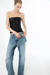Top tipo corset de escote recto y hombros descubiertos, con cierre frontal mediante ganchos metálicos y costuras verticales estructuradas.
